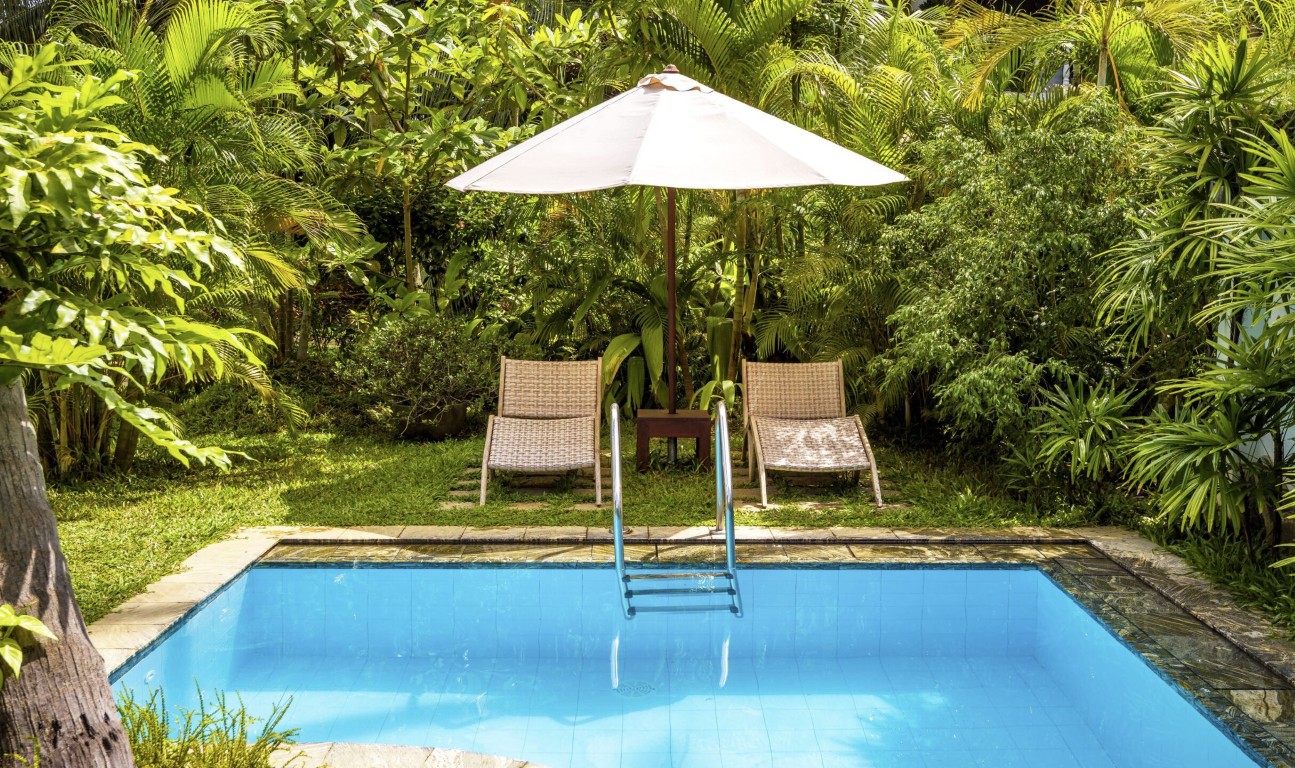 Tropical style pool with lounge chairs and professional cleaning service in Placentia, CA